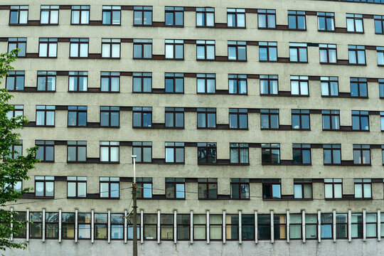 Urban facade with brown windows and reflections. The interplay of light and shadow on a modern building facade. Reflections of life. A glimpse into the stories behind the windows.