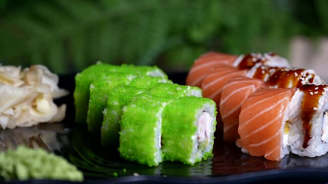 Assorted sushi rolls: green tobiko rolls and salmon rolls with sesame, beautifully plated.
