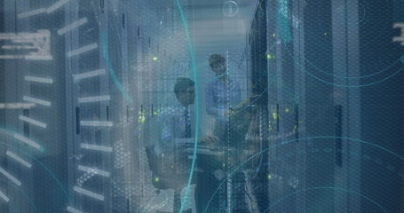 IT team configuring server racks and reviewing tablet in datacenter corridor, with network overlay