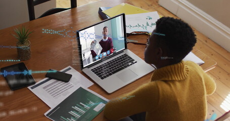 Image of data processing over african american woman having a image call on laptop at home