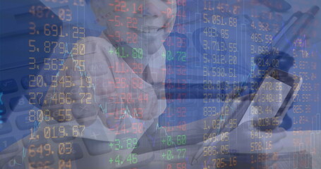 Pointing boy pressing stock market overlay at desk, with digital calculator numeric pad silver pen