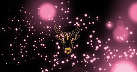Image of bull of taurus zodiac sign against illuminated floating pink particles and lens flare