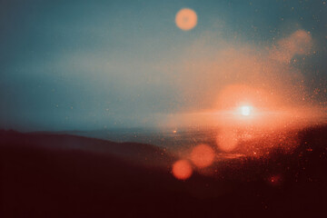 Dreamy landscape with melancholic light leak effect creates textured background, blending chaos and serenity. warm glow contrasts with cool tones of horizon