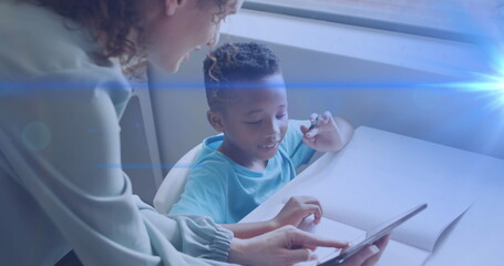 Image of light trails over diverse schoolboy and teacher using tablet