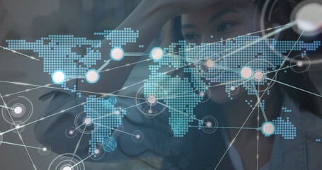 Image of network of connections with world map over woman using smartphone