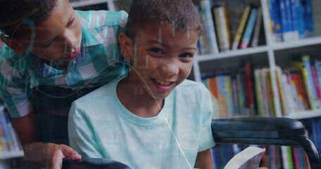 Image of graph moving over boy standing by friend reading book on wheelchair in library