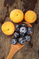 Fresh ripe whole blueberries apricot on rustic wood background wooden spoon blue berry