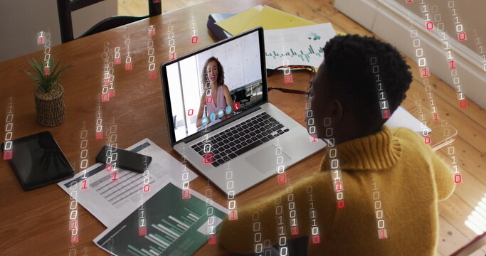 Image of binary coding over african american woman having a image call on laptop at home - Powered by Adobe