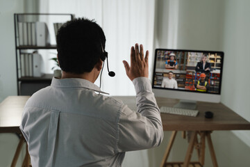 Virtual Meeting and virtual conference man white shirt participating virtual meeting computer waving to screen with multiple people video call