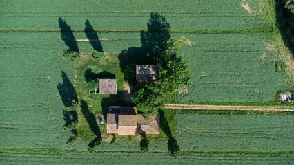 Casolare di campagna immerso in un prato verde visto dal drone