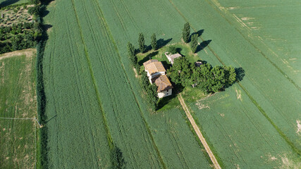 Casolare di campagna immerso in un prato verde visto dal drone