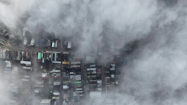Aerial view of a cityscape covered in dense, fluffy clouds, creating a serene white blanket.