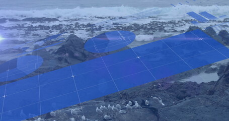 Image of blue graphs and charts moving over birds and waves splashing on rocky beach