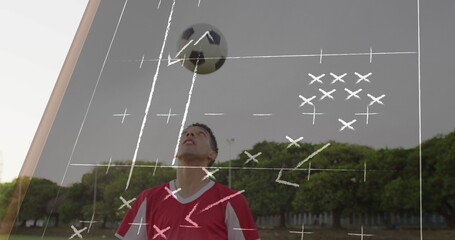 Soccer player in red jersey preparing to head soccer ball in grassy field with tactical overlay