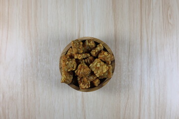 Fried tempeh in small cubes in a round teak bowl.
