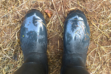 Dirty black wellingtons on the grass
