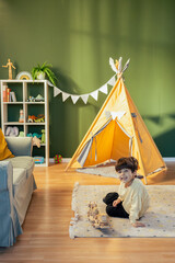 Child playing with wooden toys in a cozy playroom with teepee tent