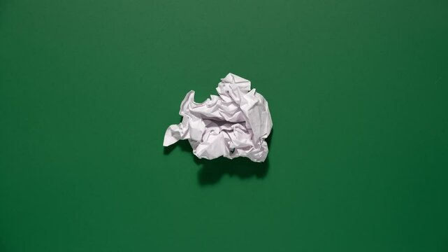 Stop motion animation of crumpled pape on a green background