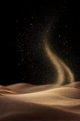 Fine golden California desert sand particles slowly lifting and dispersing in airy, graceful arcs. Natural wind motion shaping soft curves in the air, against a clean black background.