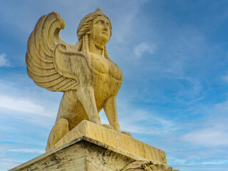 Sphinx sculpture, an ancient Greek mythical creature with the head of a woman, the body of a lion, and eagle wings, atop the National Academy. Travel to Athens, Greece.