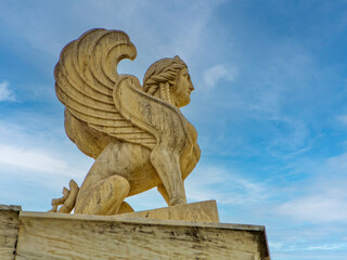 Athens, Greece, a Sphinx statue,  atop the National Academy. An ancient Greek mythical creature with the head of a woman, the body of a lion, and eagle wings.