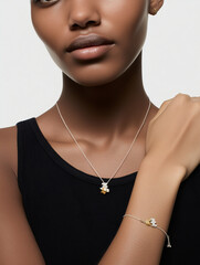 woman wearing a fine silver chain necklace with a small gold bear and another silver bear hanging from it, with her hand in front of her neck