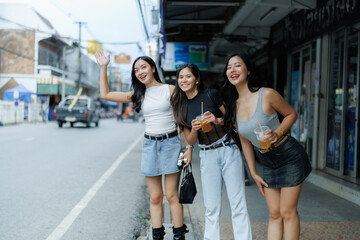 Obraz premium Group of asian women hailing a cab in thailand