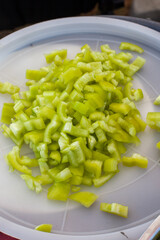 Freshly diced green bell peppers, meticulously chopped and ready for cooking or as a vibrant addition to salads