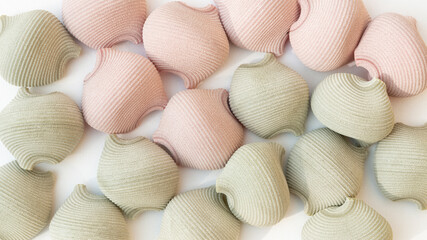 Close uo shot of pattern of round coloured textured Italian wholegrain pasta on a white background.