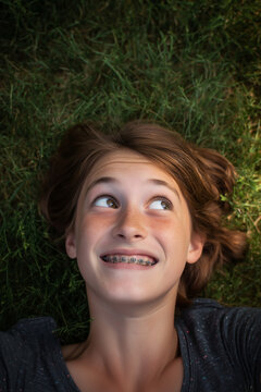 a Teen girl, awkward phase between childhood and adulthood, her face has taken on a grownup shape but her expression is one of childish playfulness and goofiness