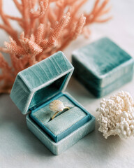 Elegant seashell ring in turquoise velvet box with coral accents, evoking coastal romance, marine luxury and beach-inspired jewelry in a soft, natural light setting.
