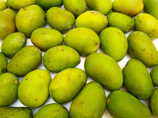 Fresh green mango fruits background, top view, tropical fruit, unripe mangoes for pickle