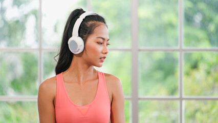 young healthy asian woman listening music while practice yoga at home