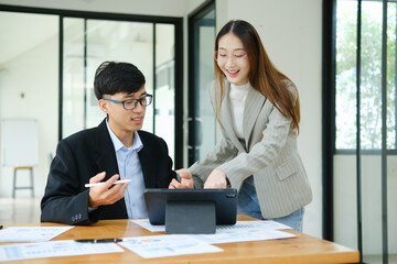 Two business people discuss financial strategy and collaborate with colleagues.