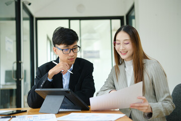 Two business people discuss financial strategy and collaborate with colleagues.