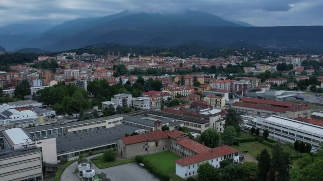 Unesco-listed Olivetti district buildings in Ivrea's framed by the Alps and Mount Mombarone in the background, drone shot, slow motion, sunny and cloudy skym, Piedmont, Italy