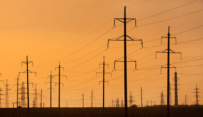 High-voltage power line in the field. Electricity pylons in the evening. Electric tower. Power transmission lines. energy security and clean energy.  