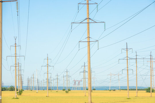 High-voltage power line in the field. Electricity pylons in the evening. Electric tower. Power transmission lines. energy security and clean energy.  