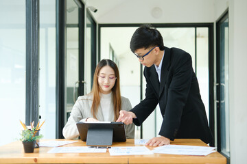 Two business people discuss financial strategy and collaborate with colleagues.