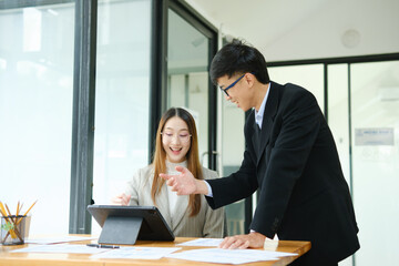 Two business people discuss financial strategy and collaborate with colleagues.