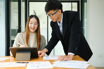 Two business people discuss financial strategy and collaborate with colleagues.