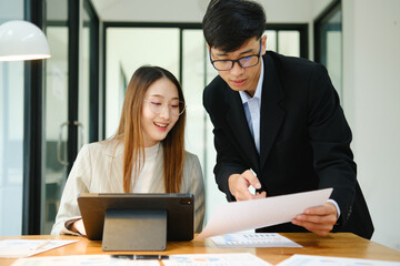 Two business people discuss financial strategy and collaborate with colleagues.