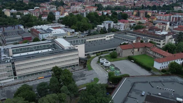 Unesco-listed Olivetti district buildings in Ivrea's framed by the Alps and Mount Mombarone in the background, drone pan shot, slow motion, sunny and cloudy skym, Piedmont, Italy