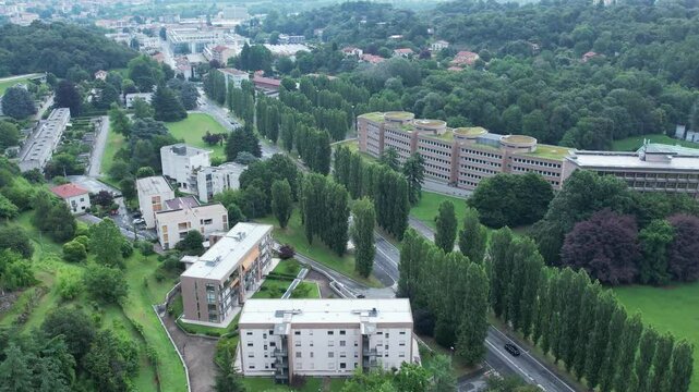 aerial of Houses for large families, by Figini and Pollini in 40s, Ivrea Olivetti industrial city, framed by green lawns, drone, slow motion.