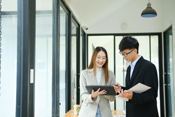 Two business people discuss financial strategy and collaborate with colleagues.