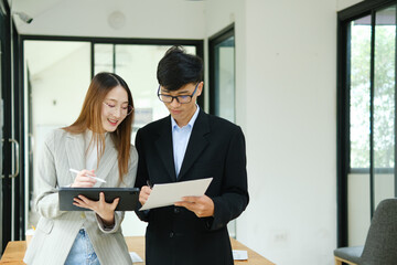 Two business people discuss financial strategy and collaborate with colleagues.