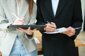 Two business people discuss financial strategy and collaborate with colleagues.