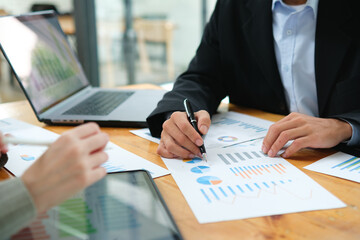 Two business people discuss financial strategy and collaborate with colleagues.