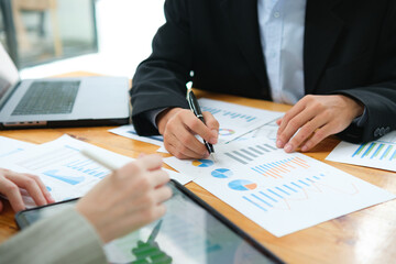 Two business people discuss financial strategy and collaborate with colleagues.