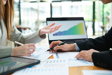 Two business people discuss financial strategy and collaborate with colleagues.